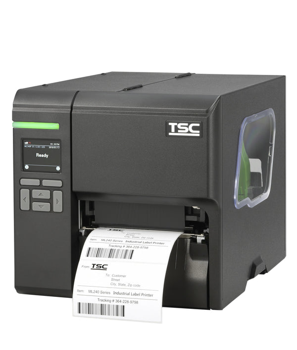 A TSC industrial barcode label printer with a dark gray and silver metallic body, showing a digital control screen on the front left and a white label sheet being printed and ejected from the front right.