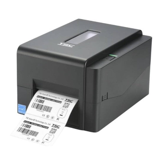 A black TSC thermal label printer with a white label sheet emerging from the front, shown on a plain white background.