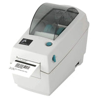 A Zebra QR-LP2824 barcode scanner with a black and gray body, featuring a digital display screen and control buttons on top, with a white paper label partially ejected from the front, set against a plain white background.