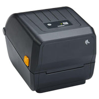 A Zebra QR-ZD23042 barcode label printer in dark gray, shown with a white label sheet partially ejected from the front. The printer features a black control panel with a small LCD screen and directional buttons, set against a clean white background.