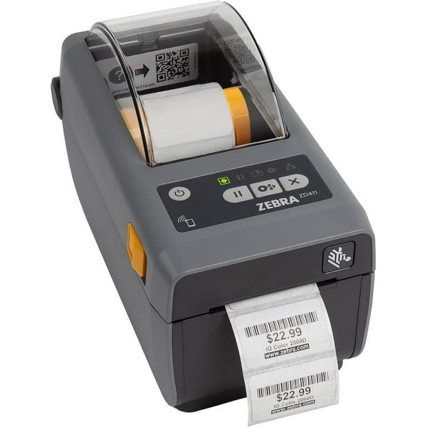 A Zebra Zebra ZD411 barcode scanner printer with a dark gray body, a white paper label emerging from the front, and a control panel with a small screen and buttons on top, set against a plain white background.