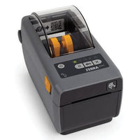 A Zebra ZD411 barcode label printer in dark gray, shown with a white label sheet partially ejected from the front. The printer features a black control panel with a small LCD screen and directional buttons, set against a clean white background.