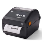 A Zebra ZD2420 thermal label printer in black, shown at a three-quarter angle with a printed label partially ejected from the front. The printer features a small orange indicator light and the ZEBRA brand name on the top panel.